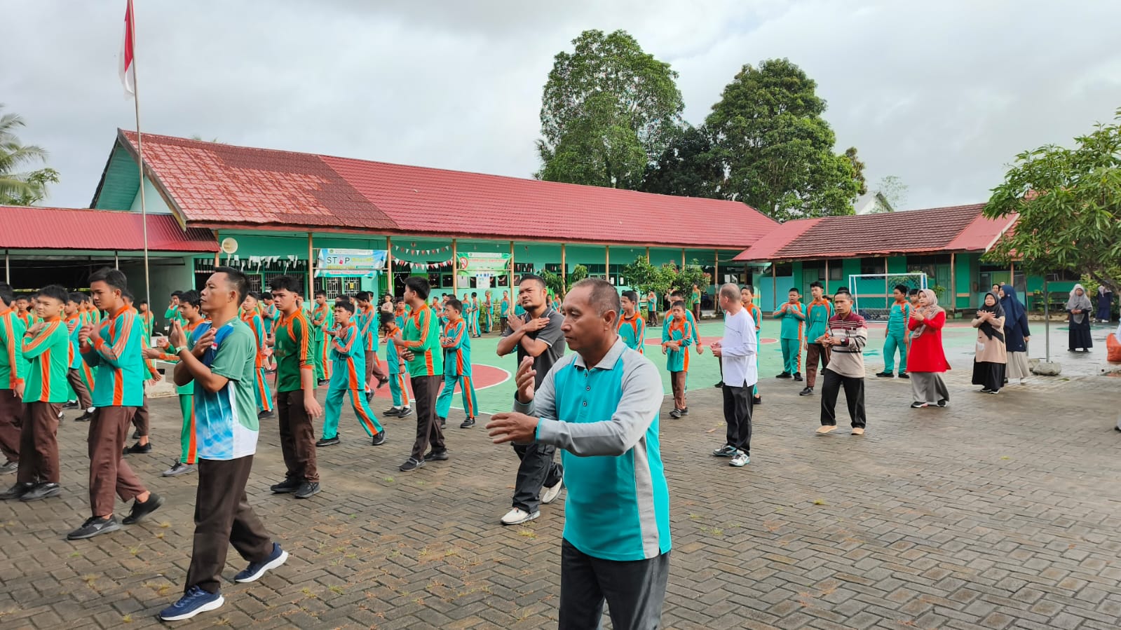 Semangat Jumat Sehat, Warga MTsN 1 HSU Bersihkan Lingkungan Saat Banjir