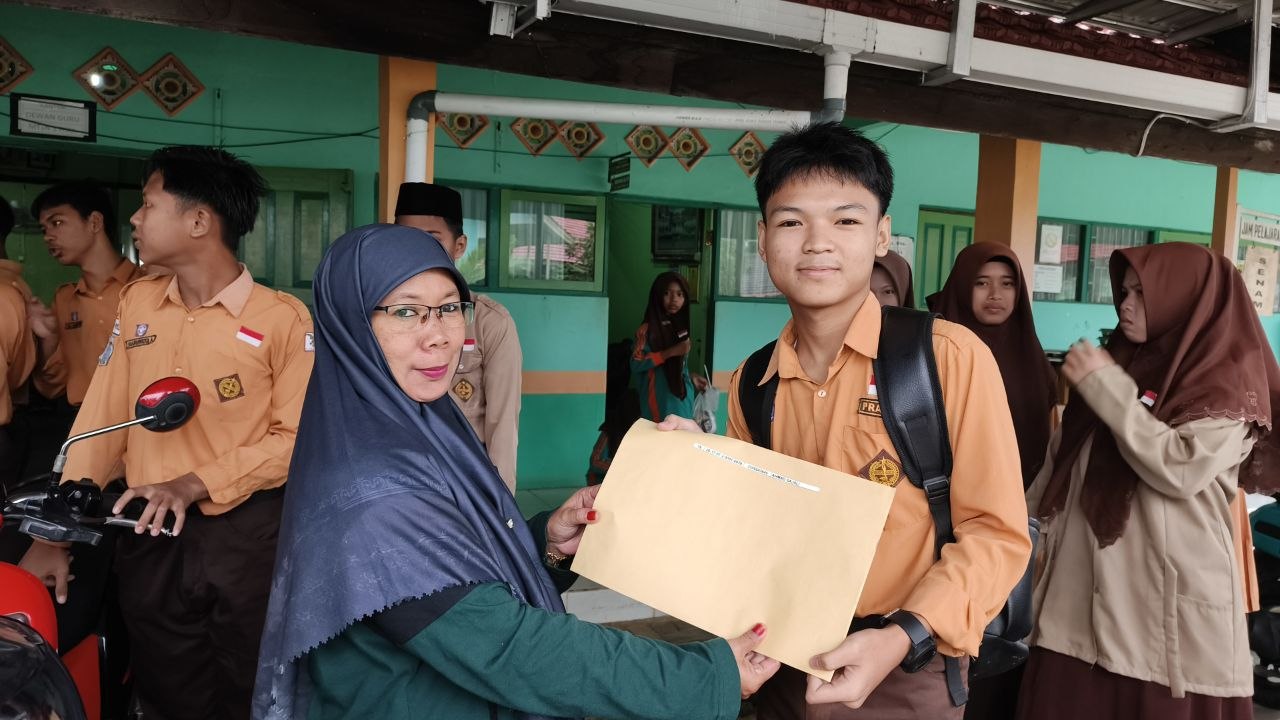 Wali Kelas IX MTsN 1 HSU Bagikan Sertifikat Hasil TKA kepada Siswa
